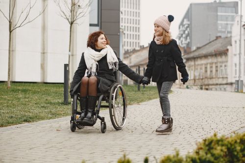 Person Pushing a Woman Sitting on a Wheelchair · Free Stock Photo