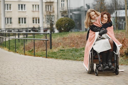 A Girl Hugging a Woman in a Wheelchair