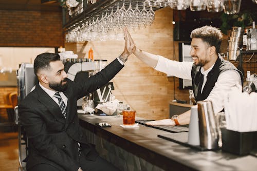 Two Men Doing High Five in the Bar
