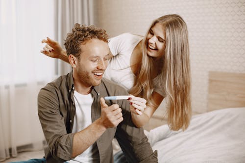 A Couple Looking at a Pregnancy Test Kit