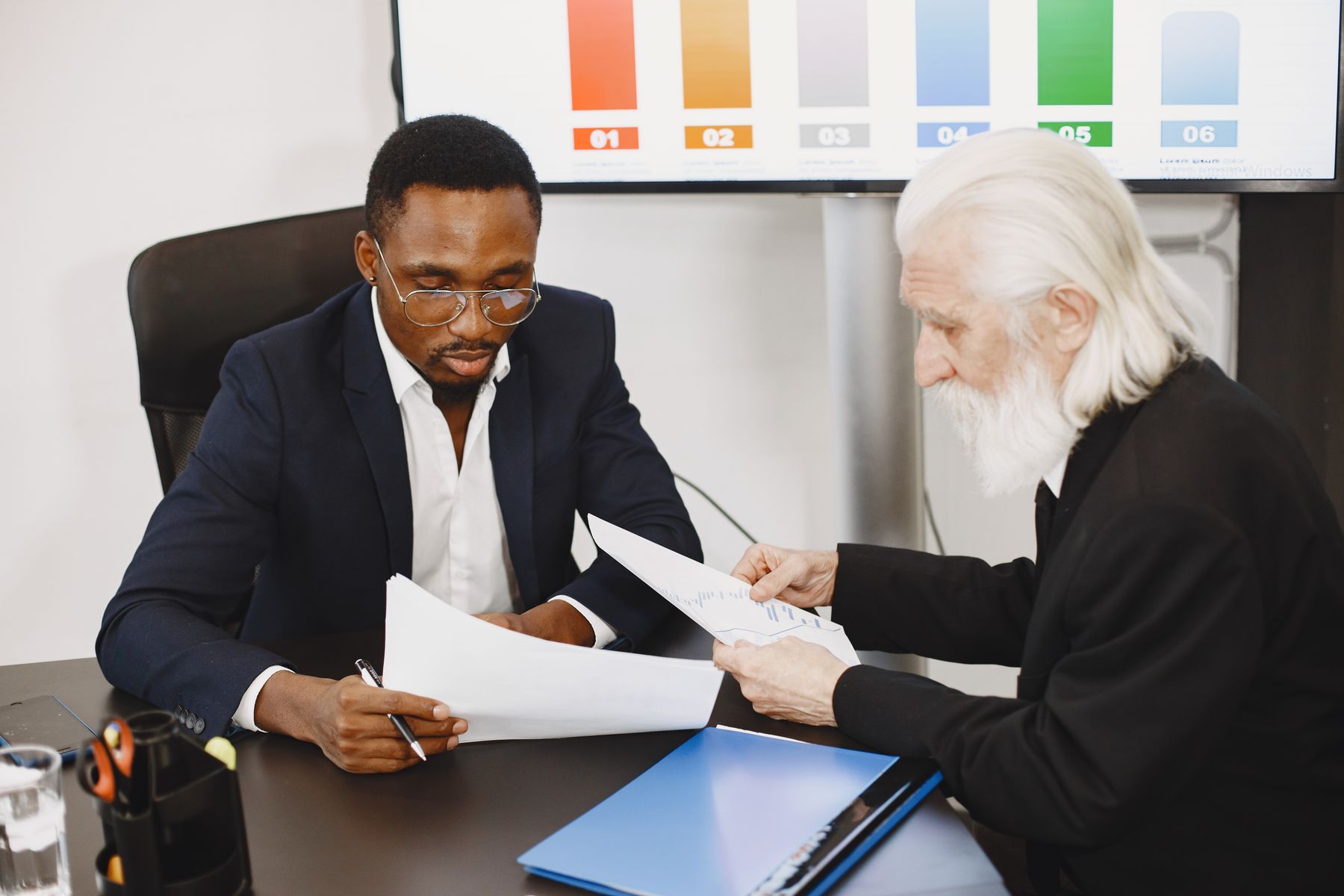 Business professionals reviewing documents during a formal office meeting