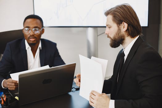 Two businessmen in a meeting discussing plans in a modern office.