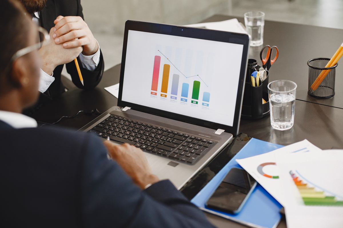 Deux professionnels analysant un graphique sur un ordinateur portable