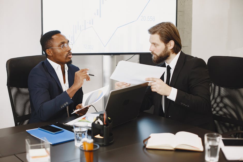 Two business professionals engaged in a planning meeting, discussing documents in a modern office setting.