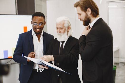 Three businessmen in suits reviewing documents in a modern office setting.