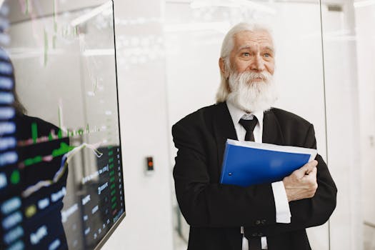 Elderly businessman in suit analyzing financial graphs in modern office.