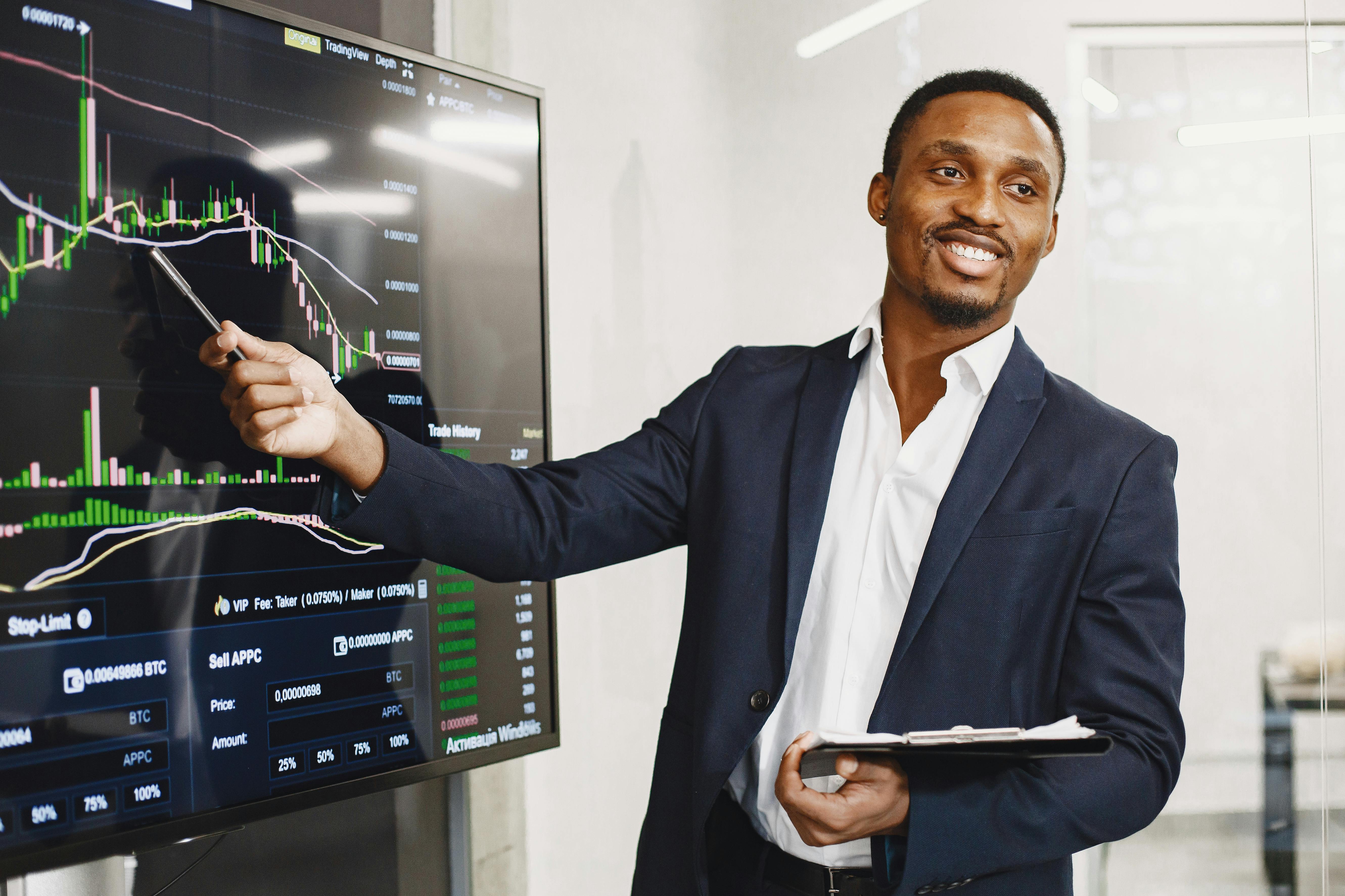 Businessman presents financial data using graphs, showcasing technology and analysis in a corporate environment.