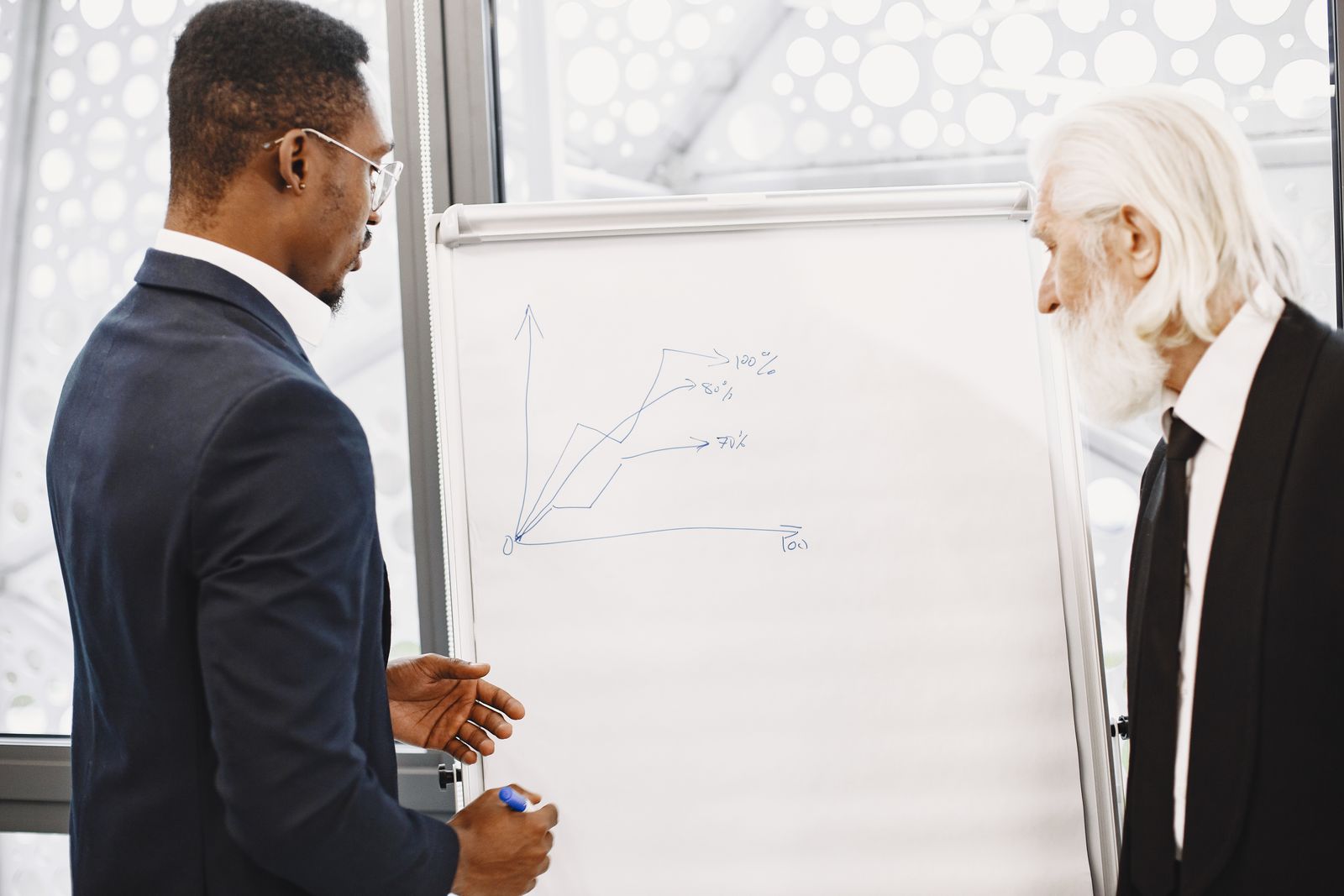 Two businessmen discussing financial charts at an office meeting