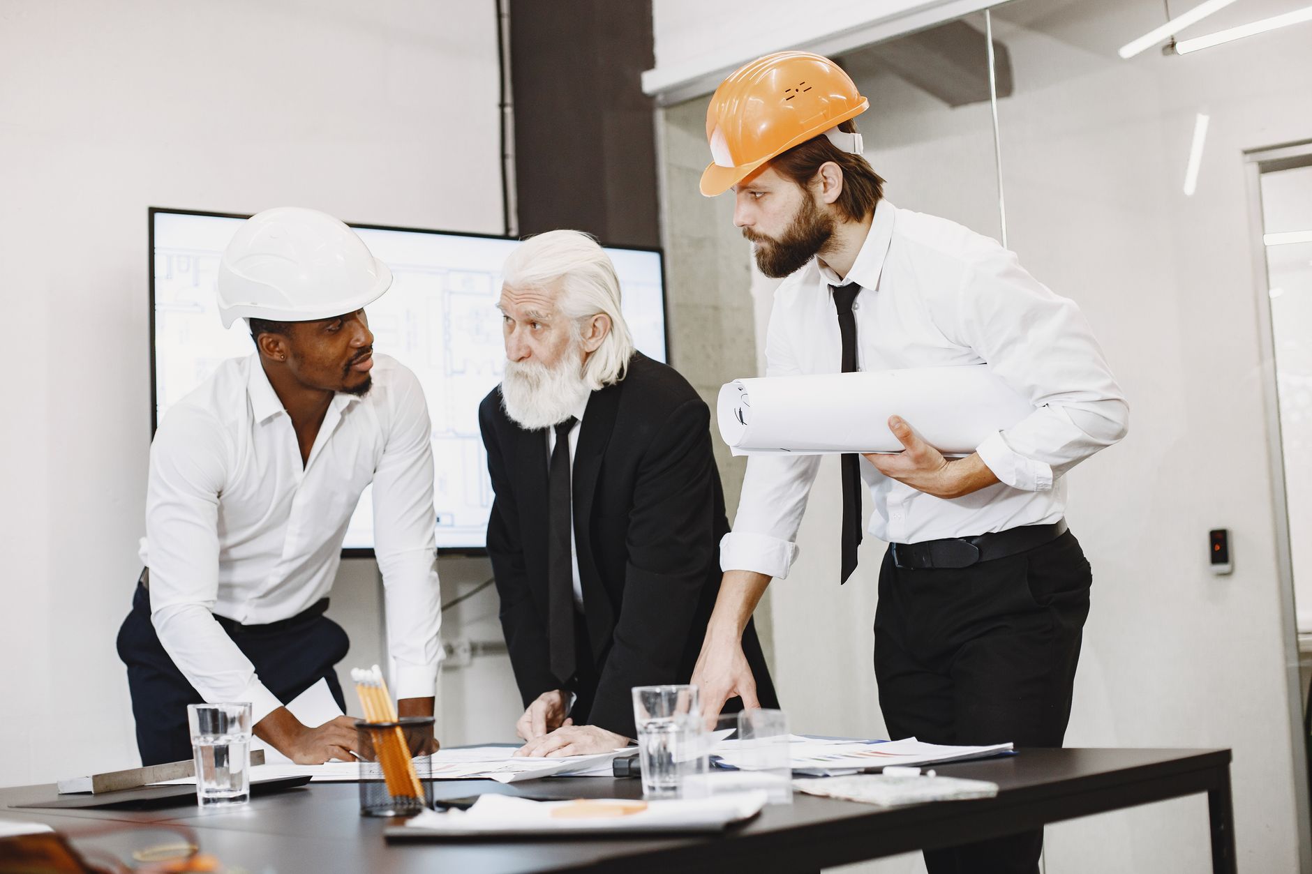 A diverse team of professionals discusses plans in an office environment.