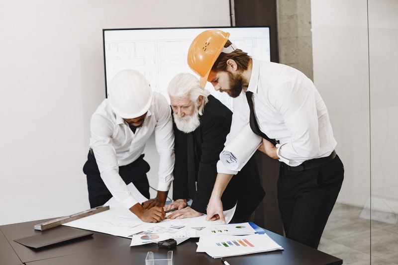 Project managers reviewing exhibit plans around a table