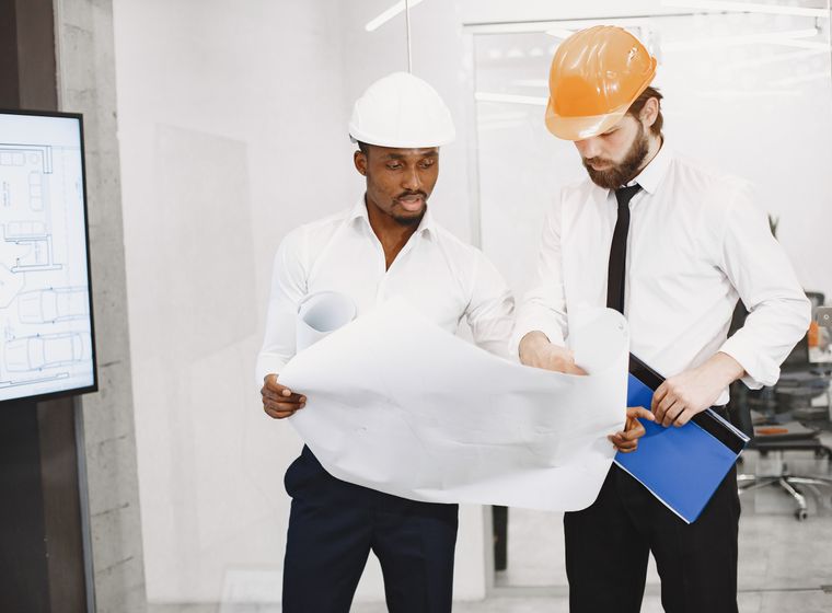 Construction professionals reviewing blueprints together