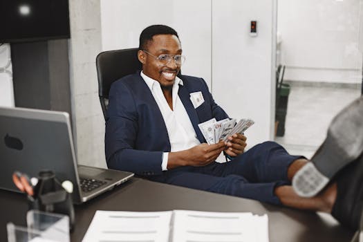 Businessman in a suit counts cash with a smile, relaxing in a modern office setting.