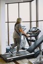 Woman in Gray Shirt and Gray Pants Standing on Black Treadmill
