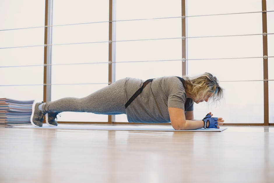 A woman in activewear doing a plank exercise indoors on a yoga mat, promoting fitness and wellness.