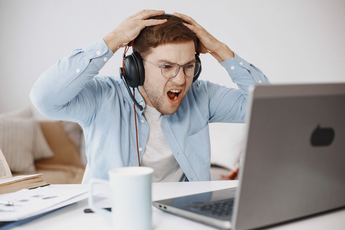 Homem frustrado diante de computador em escritório doméstico