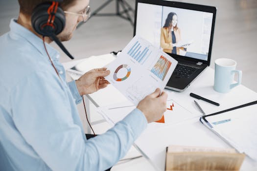 Man reviewing business charts during a remote video call, showcasing data analysis.
