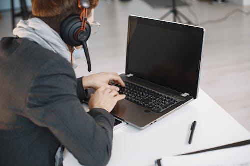 Free A Man in Black Suit Using a Laptop Stock Photo