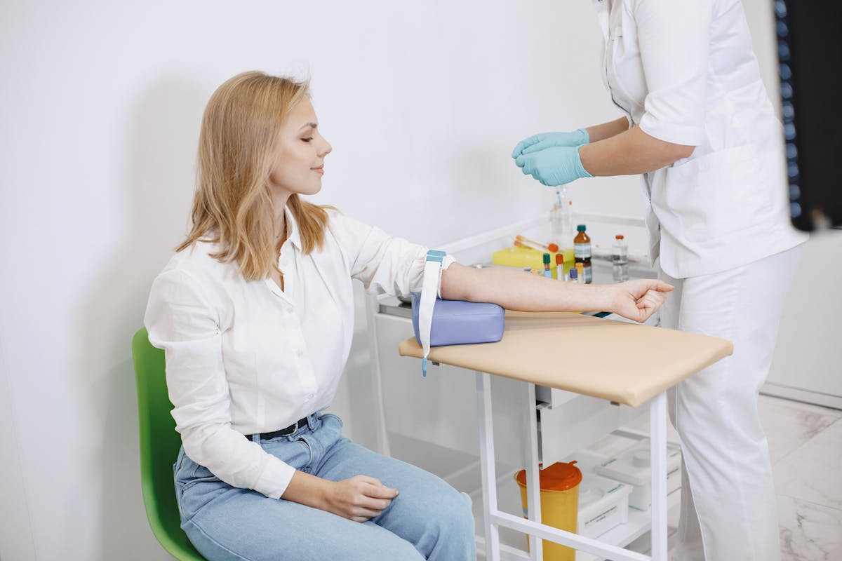 Patient seated while nurse prepares for blood collection