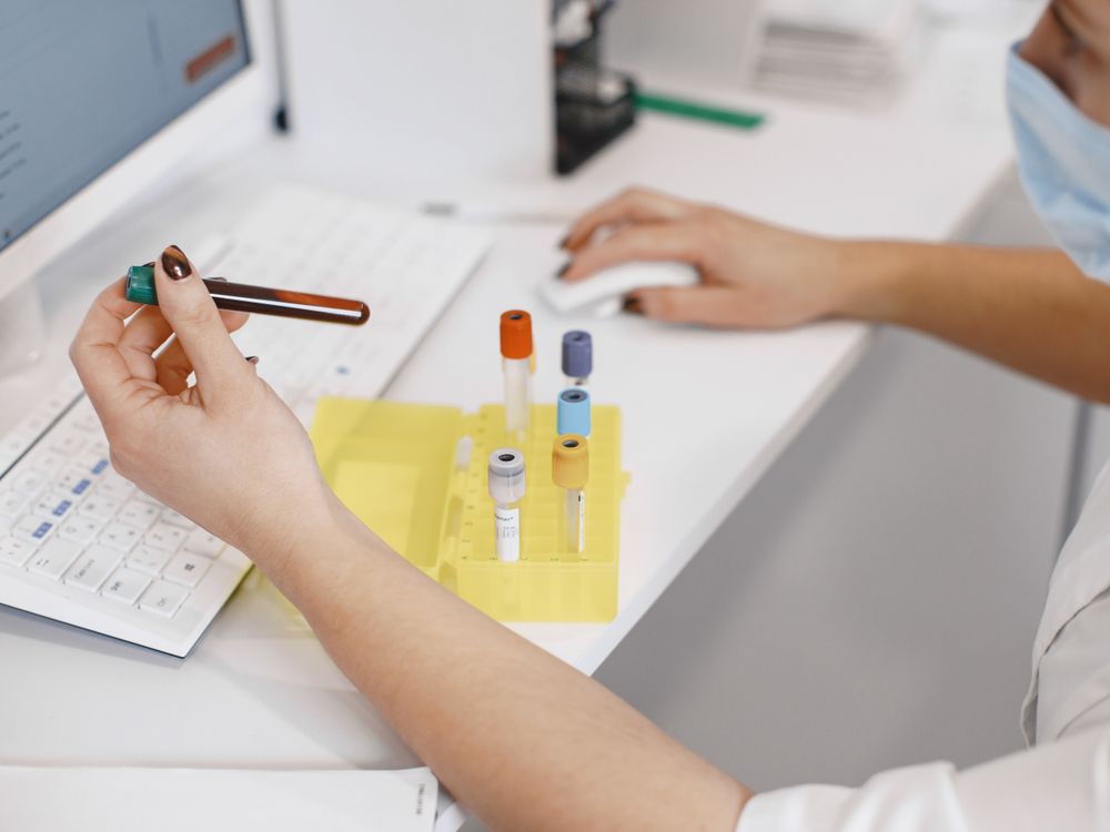 Medical worker analysing samples at a computer