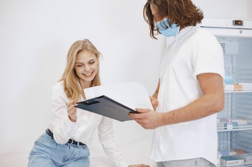 Free A patient happily reviews her medical results with a doctor in a clinic setting. Stock Photo