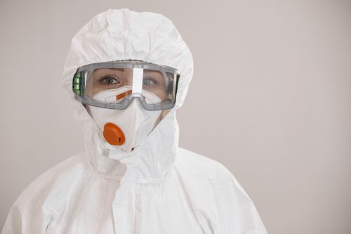 Free Healthcare worker in protective suit with mask and goggles for COVID-19 safety. Stock Photo