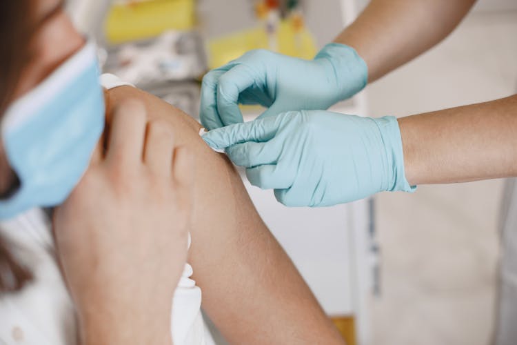 Nurse Putting A Adhesive Bandage On A Patients Arm 