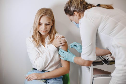 Nurse delivering vaccine shot to woman in a clinic setting. Medical and healthcare concept.