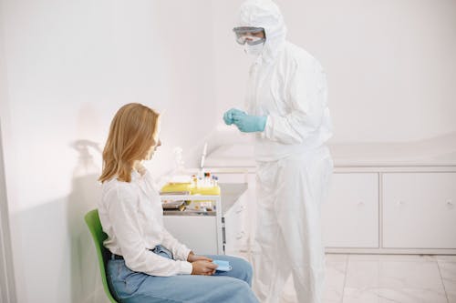 A Medical Professional in Personal Protective Equipment attending a Patient