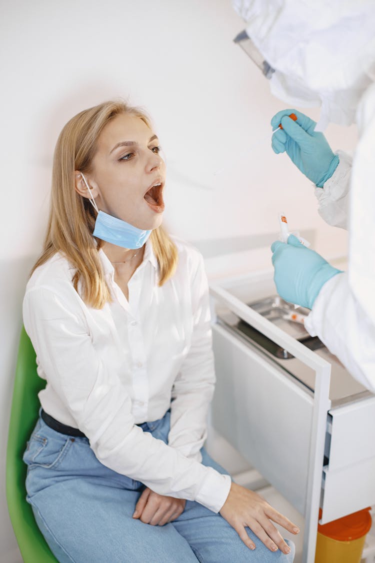 A Patient With Her Mouth Open Getting A Swab Test