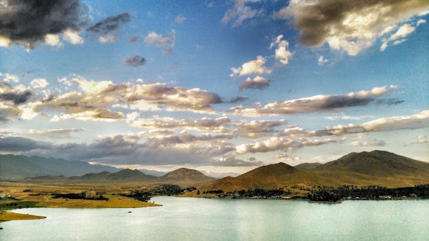 白天的喀布尔，多云天空下映衬着壮丽的山脉和湖泊景色