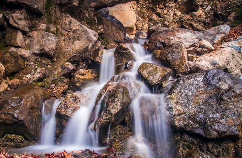 Free Capture of a tranquil waterfall cascading over rugged rocks, showcasing nature's beauty. Stock Photo