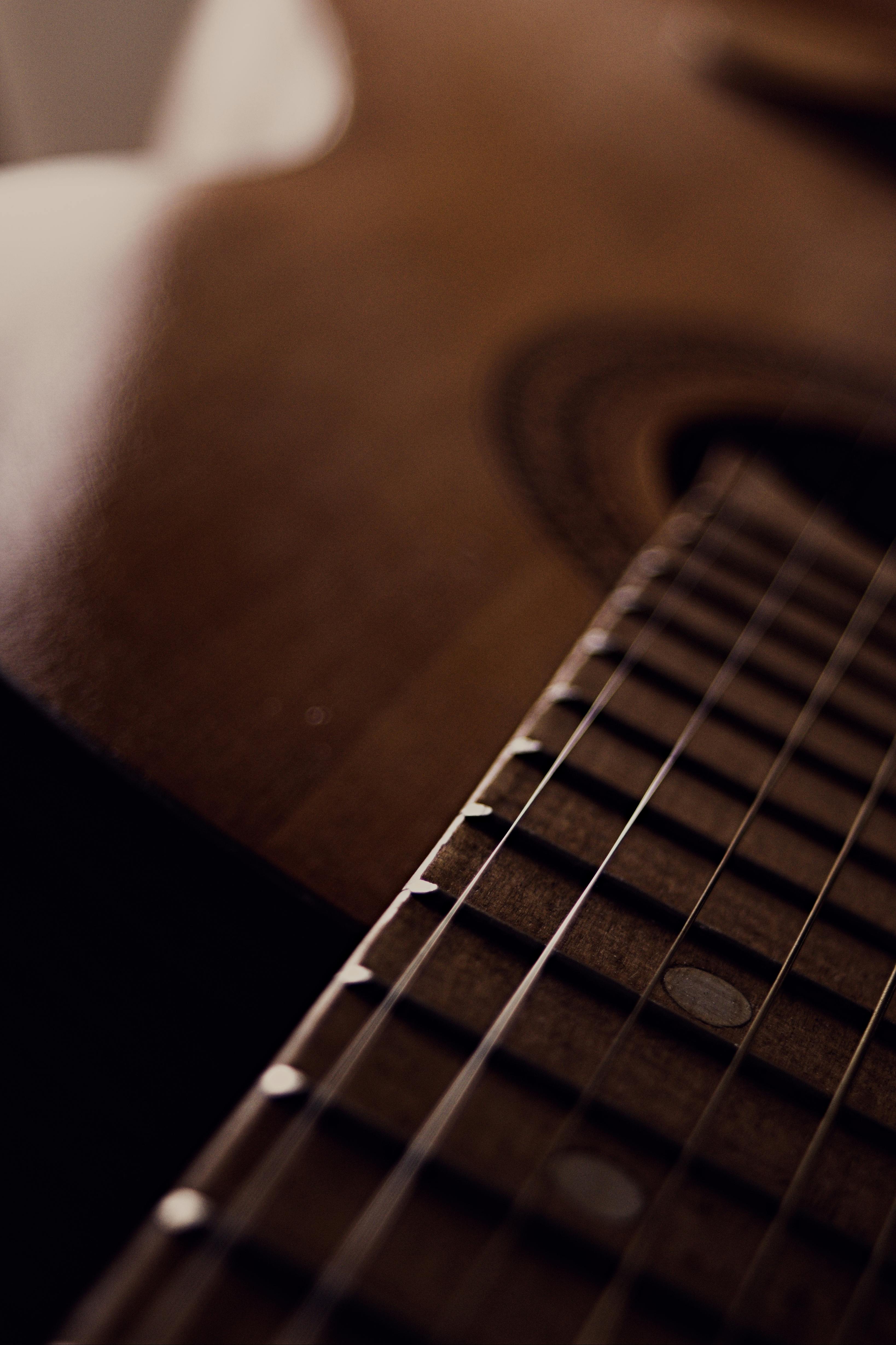 Brown acoustic guitar on black chair photo  Free Guitar Image on Unsplash