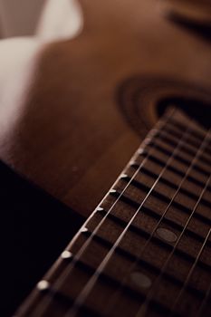 Detailed close-up of acoustic guitar strings and fretboard in soft focus.