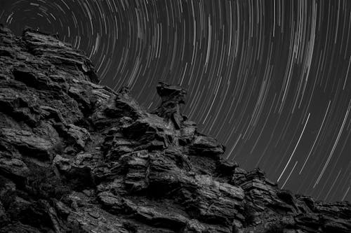 Free Grayscale Photo of a Rocky Mountain under a Starry Sky Stock Photo