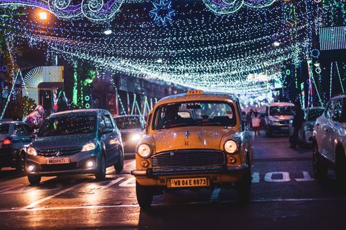 Free Modern cars and vintage vehicles driving on busy road under garland in city at night Stock Photo