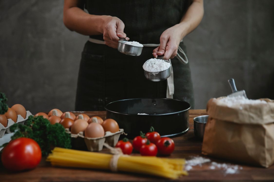 Anonymous chef cooking pasta on table near ingredients · Free Stock Photo
