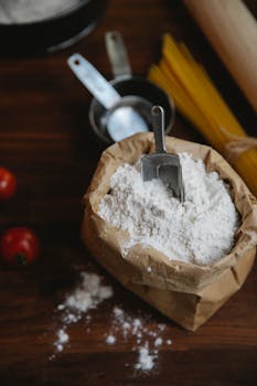 A cozy kitchen scene showcasing flour and pasta for cooking, captured from a high angle.