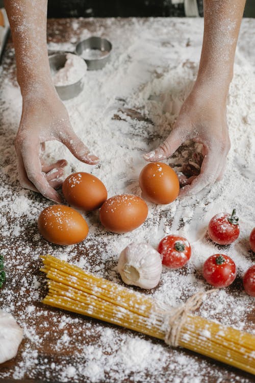 Free Person preparing for cooking with flour scattered on table Stock Photo