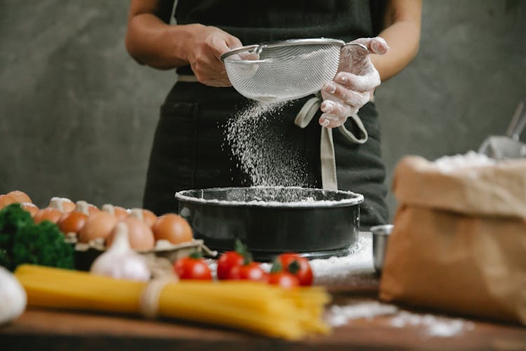 Cook Sifting Flour Through Sieve For Dough