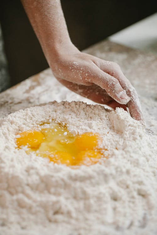 Chef mixing flour and eggs for dough