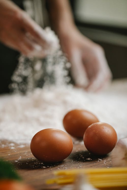 Free Person preparing flour for making dough with eggs Stock Photo