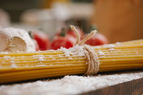 Free Closeup of ingredients for cooking Italian dish consisting of spaghetti tomatoes and garlic with flour Stock Photo