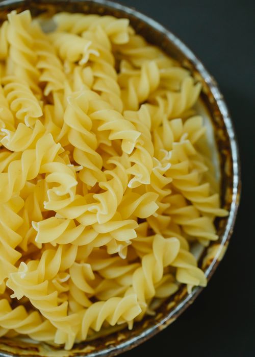 Free From above of dried uncooked traditional Italian fusilli pasta in bowl on table Stock Photo