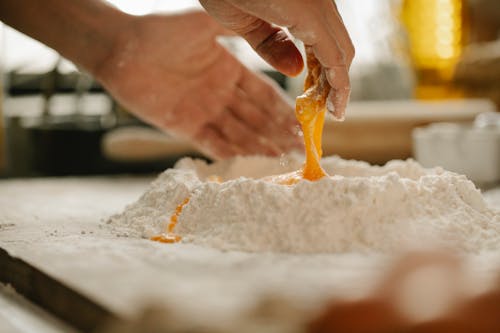 Chef mixing egg with flour for making dough