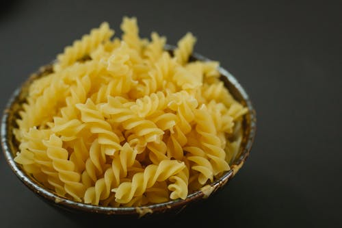 Bowl of raw fusilli on table