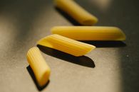 Raw penne rigate on dark surface