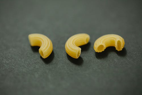 From above of uncooked curvi rugati macaroni placed on gray table in kitchen