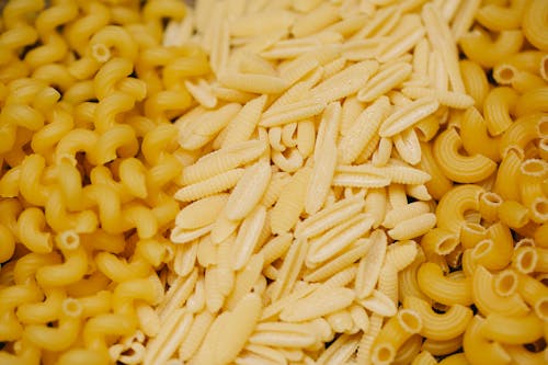 Pile of assorted small pasta types scattered on table