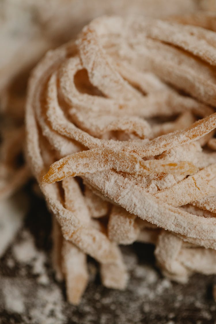 Nest Of Uncooked Linguine Pasta Placed On Floury Table