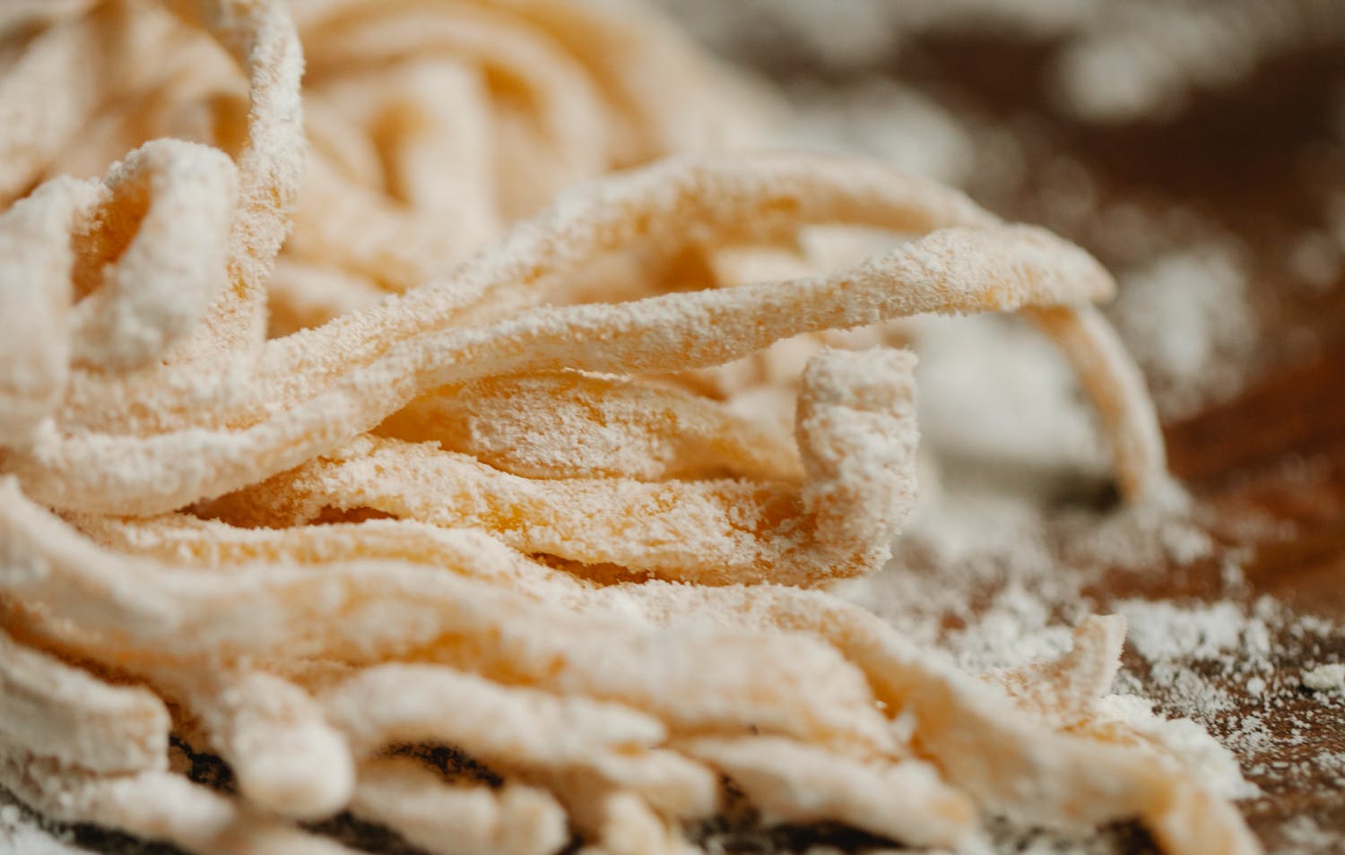 Close-up view of freshly made homemade tagliatelle pasta dusted with flour